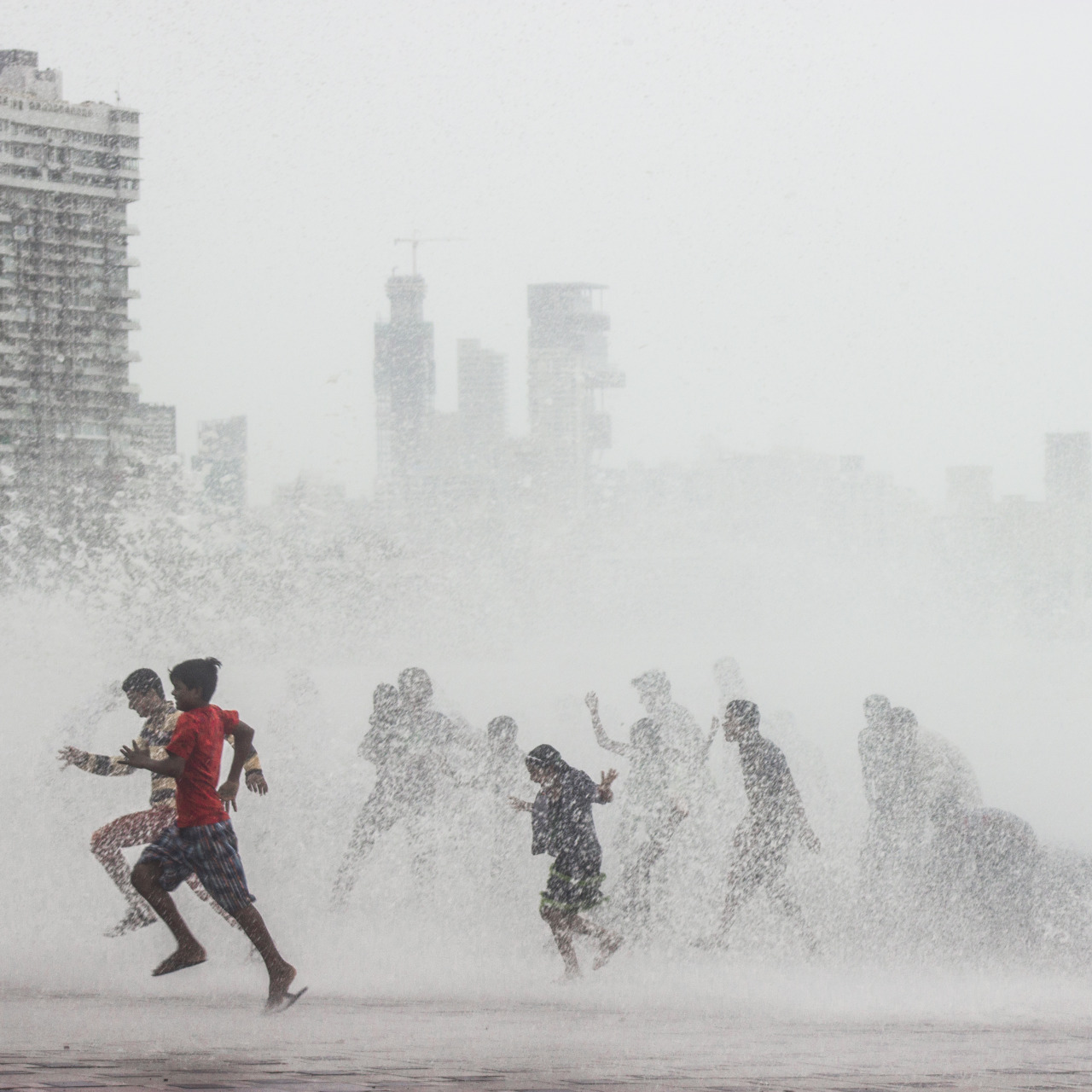 Children have a fun day out as towering waves drench them completely at high tide.
Taken at Worli sea face.
Bombay / Mumbai, India.